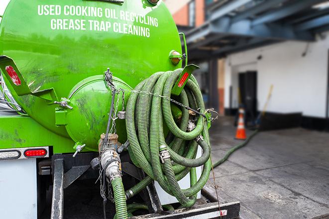 worker pumping grease trap at commercial kitchen in Deer Park, NY